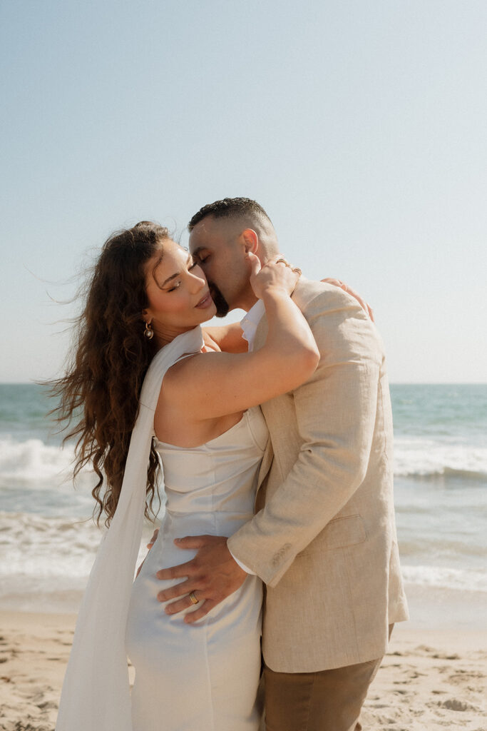 groom kissing the bride on the cheek