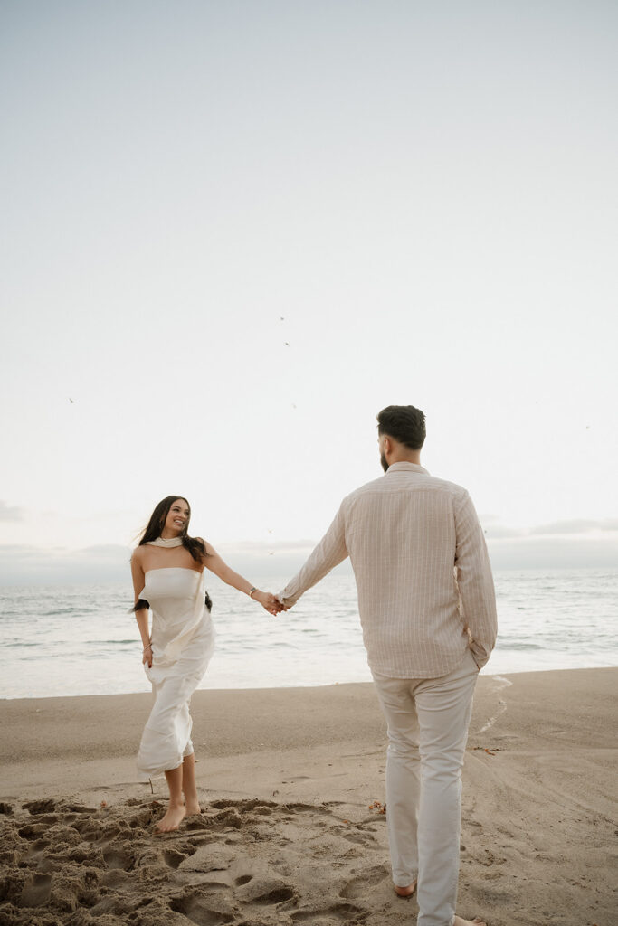 cute couple holding hands during their beach engagement session