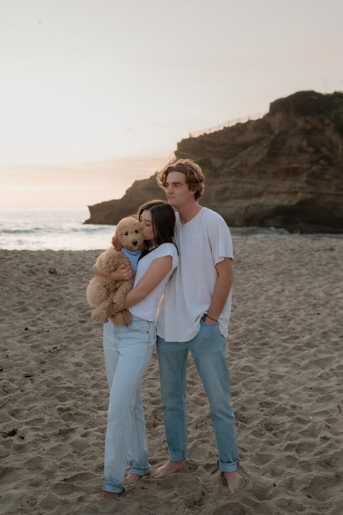 happy couple with their dog at their beach couples session