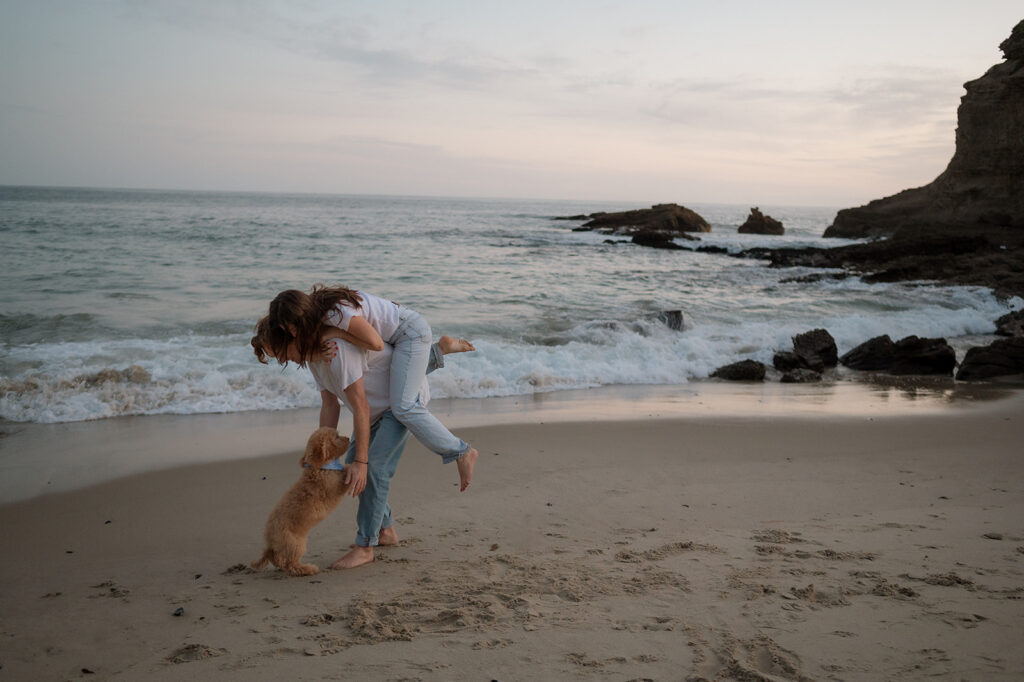 cute couple playing during their photoshoot at the beach 