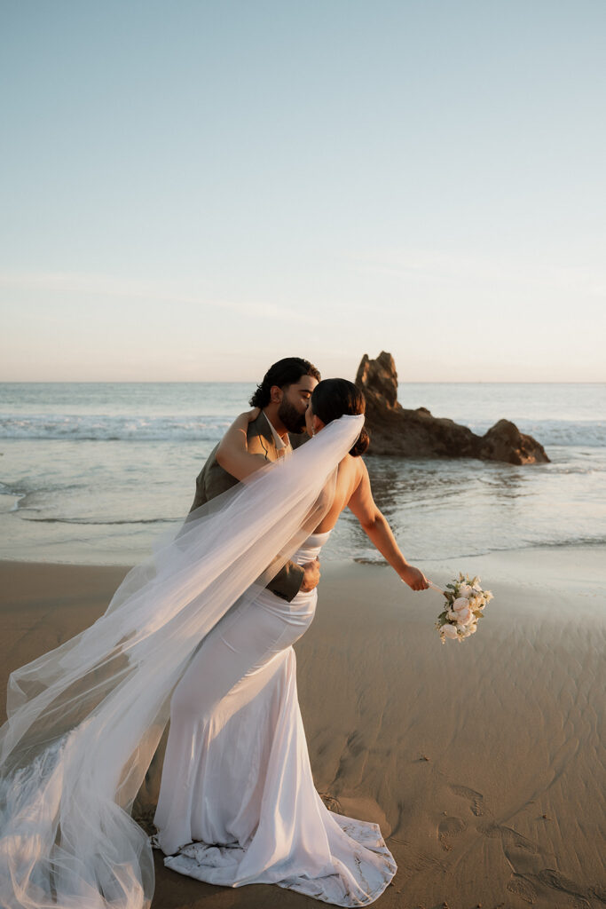 bride and groom dancing at the beach 