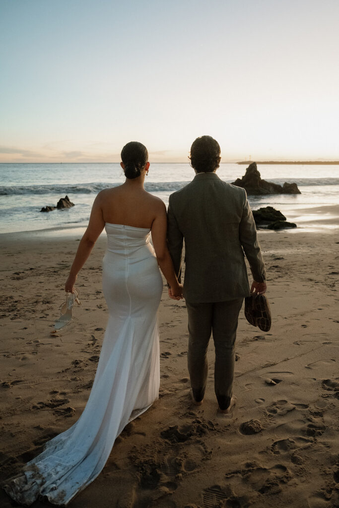 bride and groom holding hands at the beach 