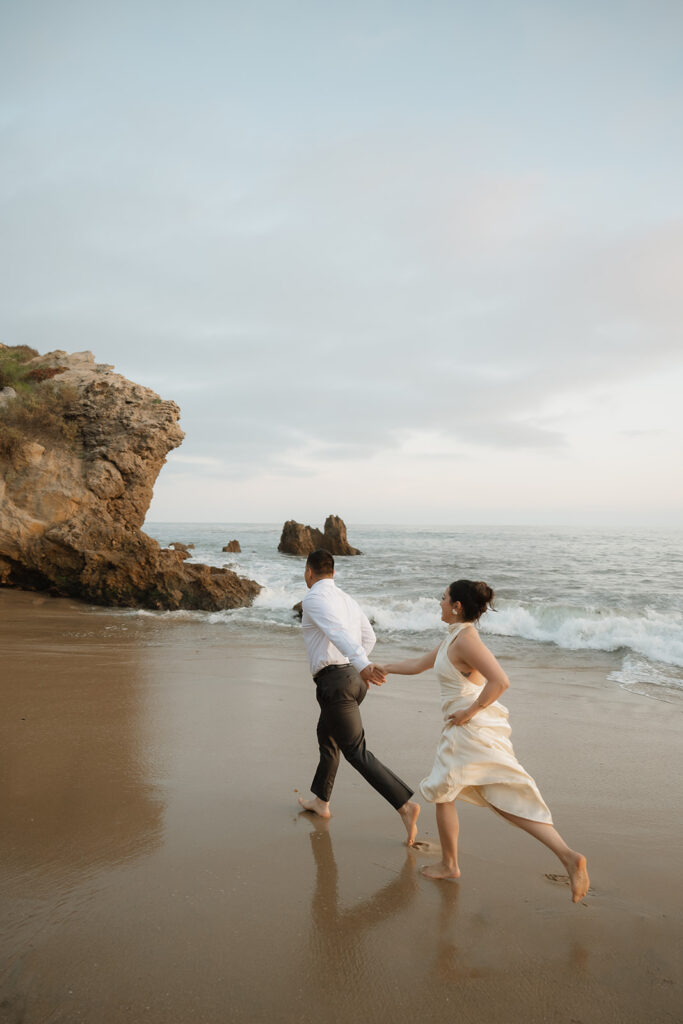 cute couple running around the beach during their photoshoot