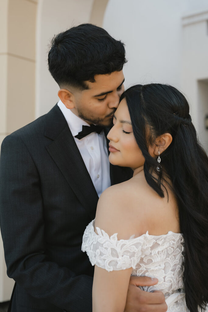 groom kissing the bride on the forehead