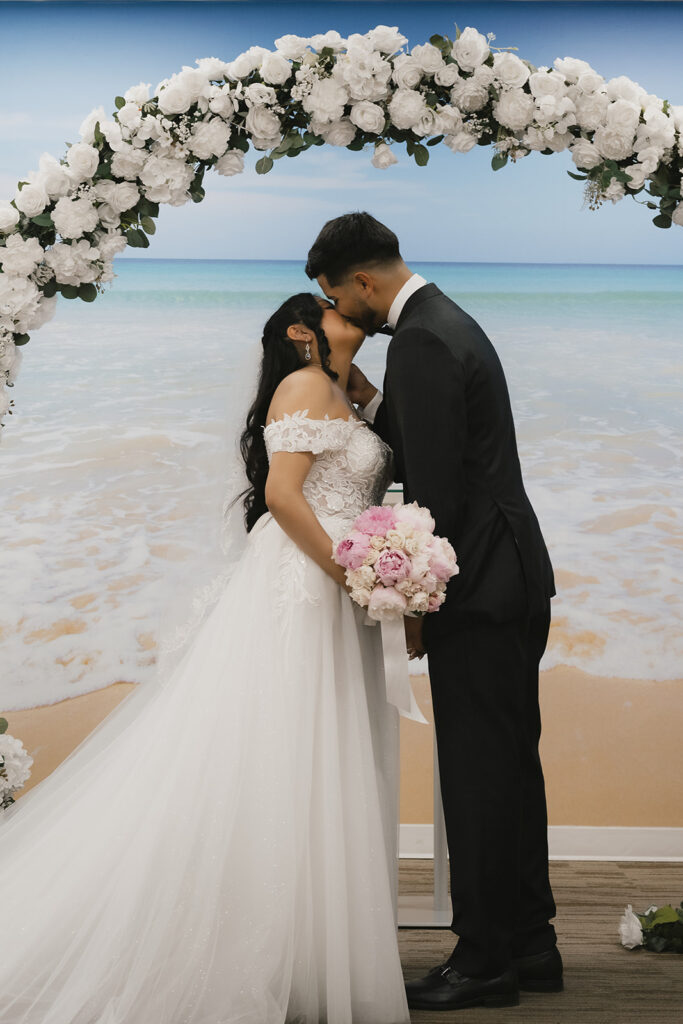 portrait of the bride and groom kissing after their ceremony
