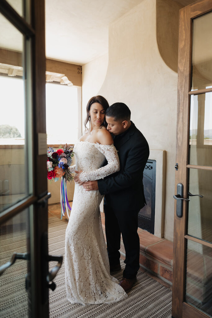 Groom, kissing the bride on the shoulder