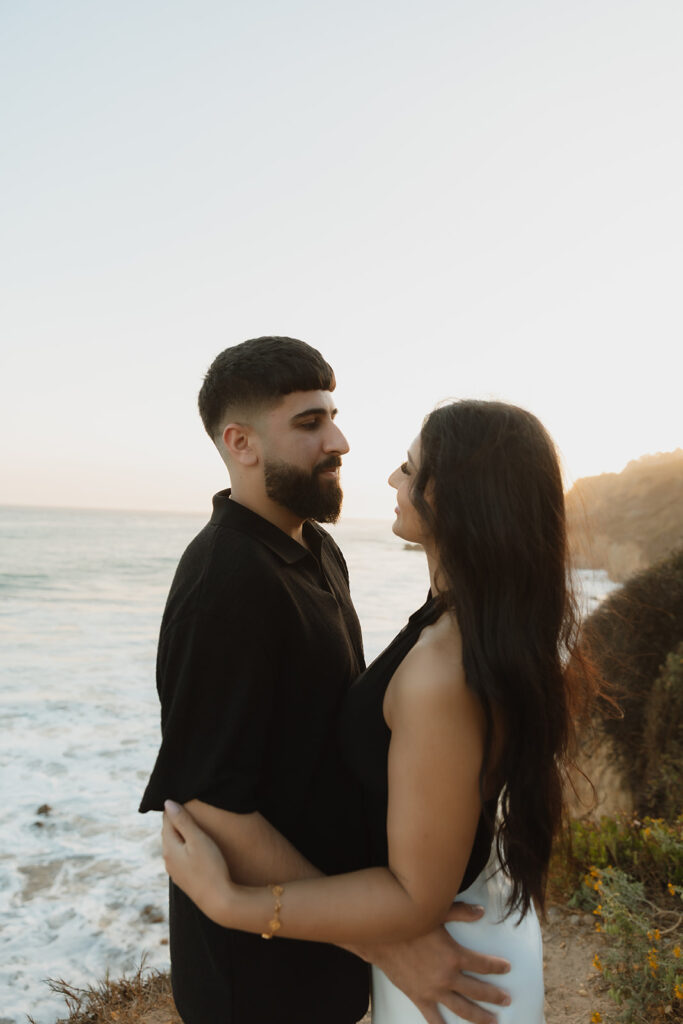 picture of the newly engaged couple smiling at each other